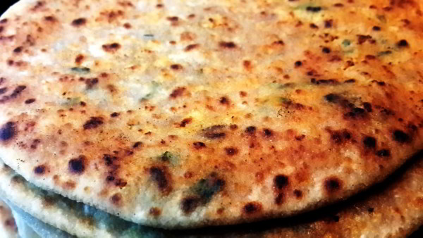 A close-up image of Chicken Keema Paratha, showcasing golden-brown, flaky bread stuffed with seasoned minced chicken, a delicious Indian delicacy.