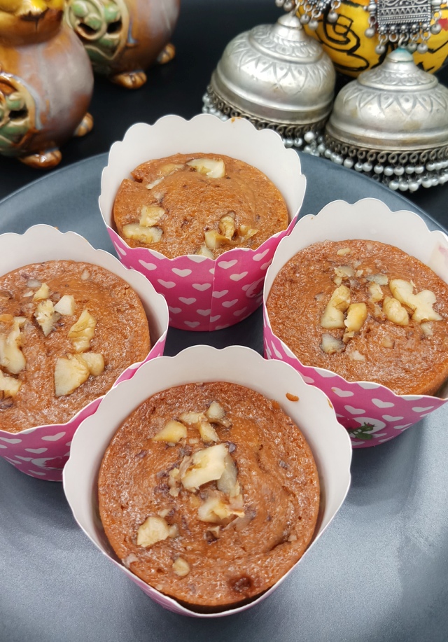 Eggless Wheat Flour Cupcake is in baking cups on black table.