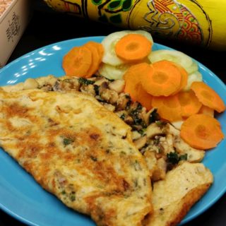A golden-brown delicious stuffed omelette recipe served with a side of salad.