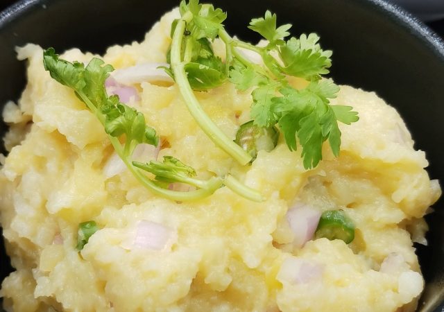 Authentic Aloo Ka Bharta - Mashed potatoes with garnished cilantro and served with flatbread.