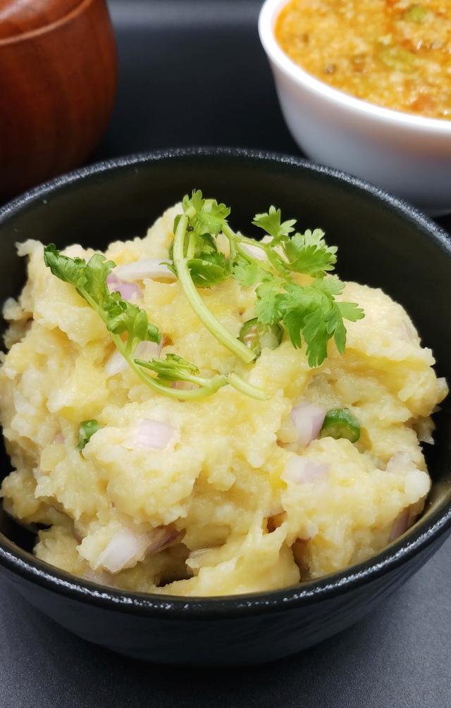 Authentic Aloo Ka Bharta - Mashed potatoes with garnished cilantro and served with flatbread.