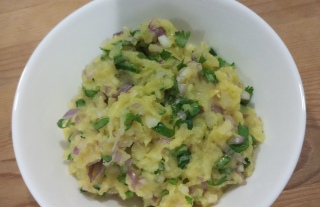 Authentic Aloo Ka Bharta Recipe in white bowl on brown table.