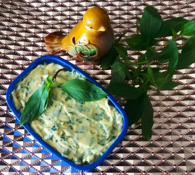 Basil Bliss Butter: Homemade Gourmet Delight mix in blue container on copper tray with some basil leaves.