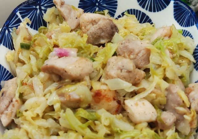 Asian Cabbage Stir Fry is in blue rectangle bowl on black mat.