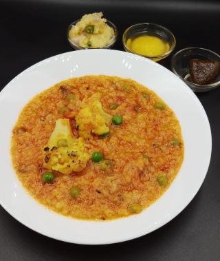 Masala khichdi in white plate on black table.