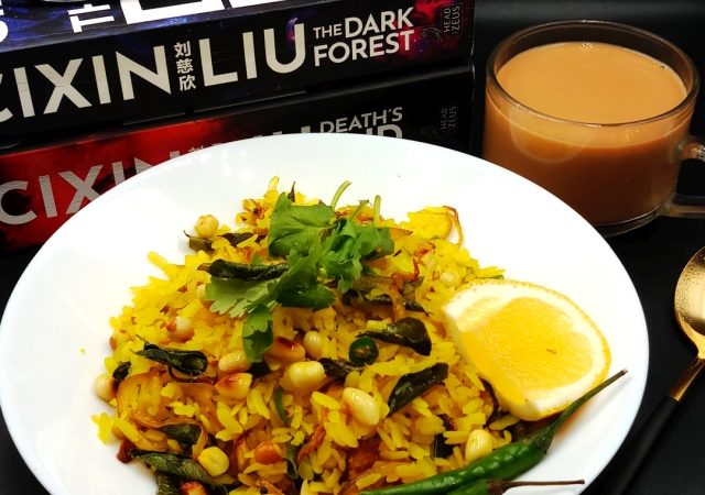 A plate of freshly prepared Kanda Poha topped with cilantro and peanuts.