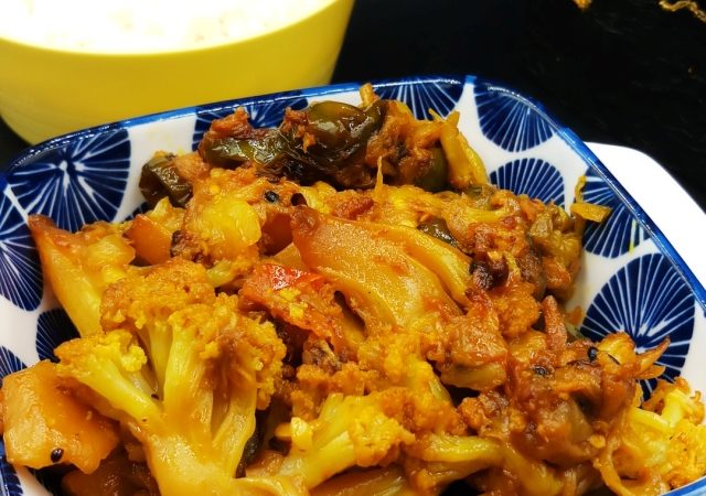 Delicious Bengali Mixed Vegetable Recipe - Traditional Flavors in white bowl on black mat.