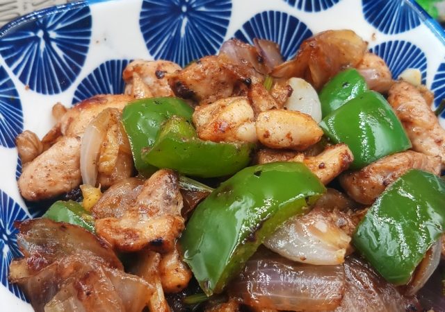 Delicious Chicken Stir-Fry Recipe | Quick and Easy Asian Dish in a blue bowl on black mat.