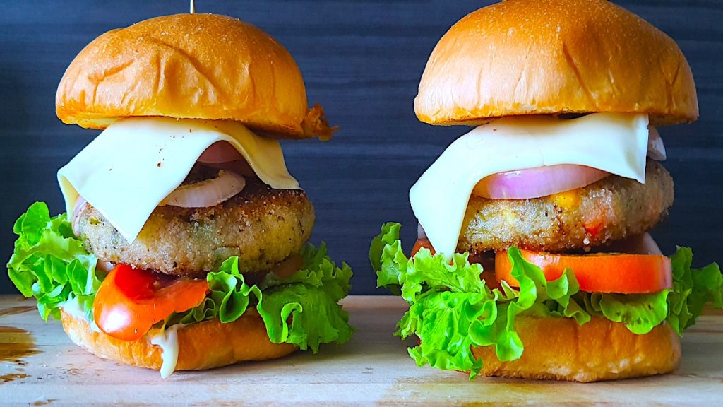 Mouthwatering veg burger recipe with lettuce, tomato, onion, cheese, and a seasoned veggie patty served on a toasted bun.