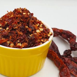 A close-up of freshly ground homemade chili flakes in a bowl.