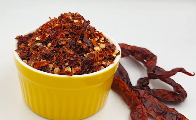 A close-up of freshly ground homemade chili flakes in a bowl.