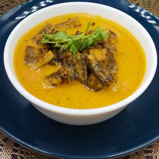 A bowl of Sarson Wali Bhindi with boiled rice, a traditional Indian dish featuring bhindi in a mustard-flavoured gravy.