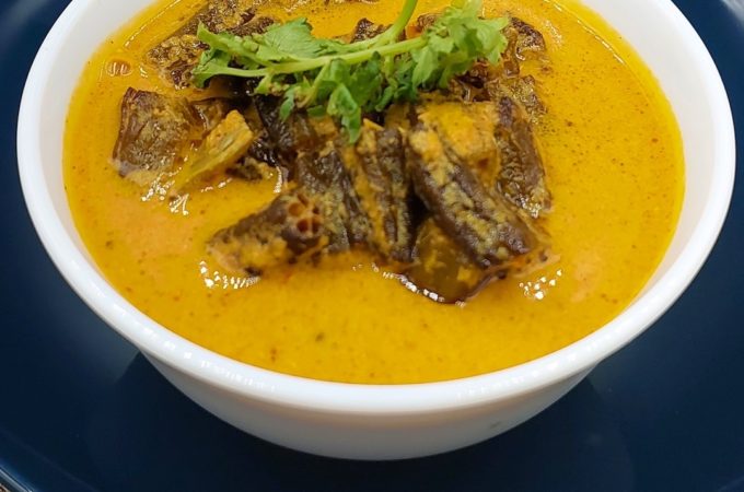 A bowl of Sarson Wali Bhindi with boiled rice, a traditional Indian dish featuring bhindi in a mustard-flavoured gravy.