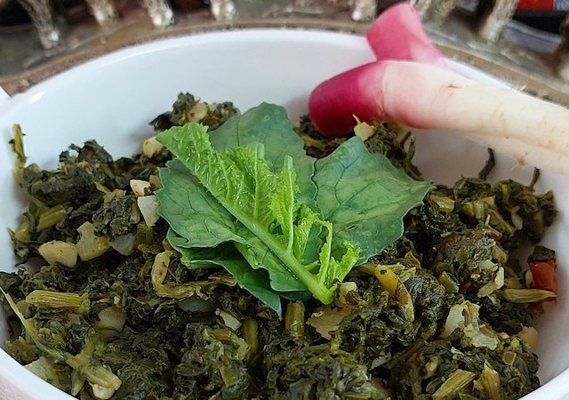 Aromatic mouthwatering homemade mooli ka saag in a white bowl.