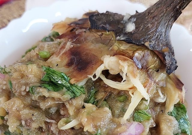 A bowl of smoky Baigan ka Bharta garnished with fresh coriander leaves.