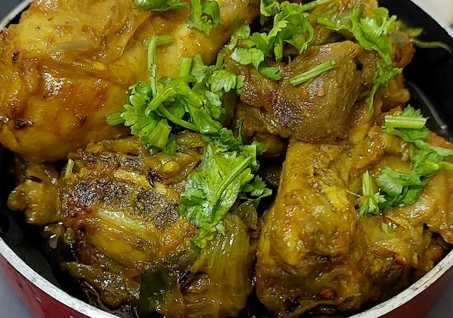 "Jhatpat Chicken Recipe - Spicy chicken in a pan with aromatic spices and fresh coriander leaves."