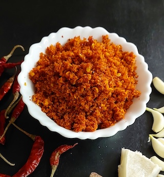 A bowl filled with homemade dry garlic chutney, showcasing its vibrant colours and texture.