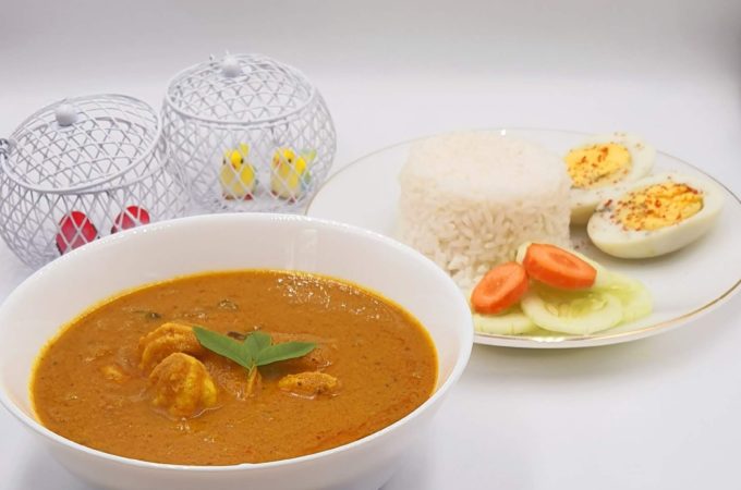 Authentic Goan prawn curry served in a white bowl along with white rice.