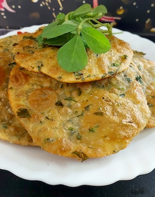 Fresh Methi Leaves Ki Puri frying in hot oil, golden brown and crispy.
