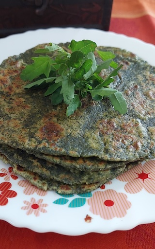Bathua Saag Parathas Recipe served on a plate, garnished with bathua leaves.