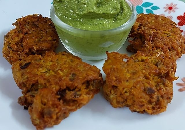 Moringa Flower Fritters served with coriander chutney in white plate.