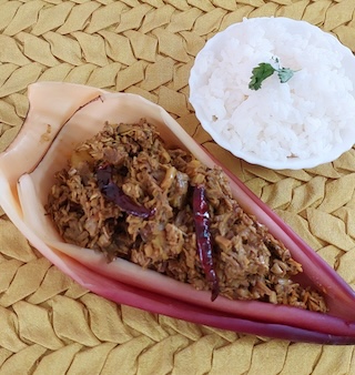 A Mochar Ghonto Recipe (banana blossom) garnished with dry red chili.

