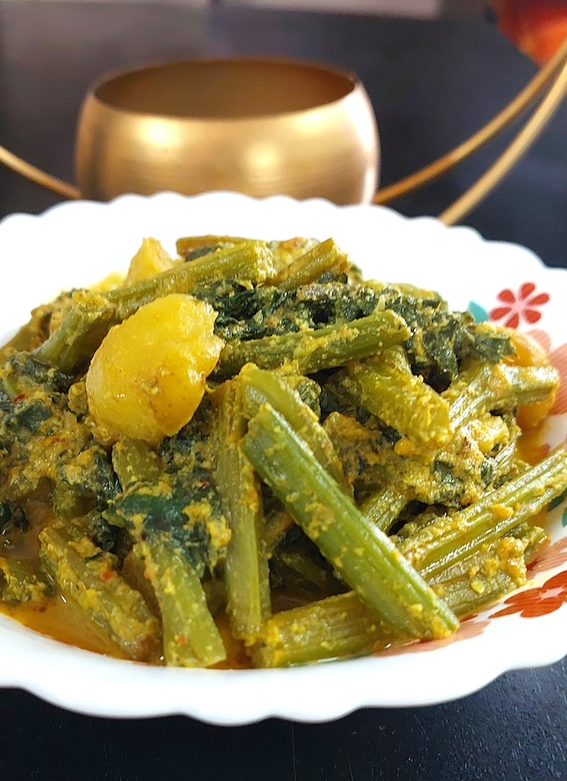 Bottle Gourd Leaves Curry / Lau Shak Recipe served in white bowl.